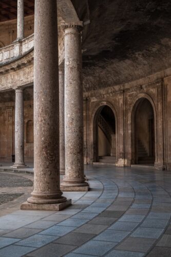 Elegant stone columns and arches in the Alhambra Palace, showcasing classic architecture.