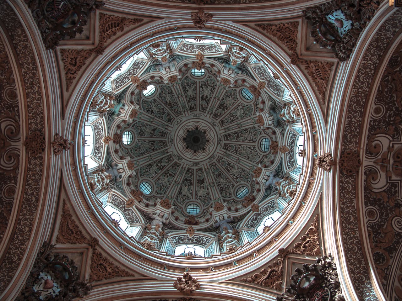 A stunning view of the intricate dome ceiling inside the Granada Cathedral.