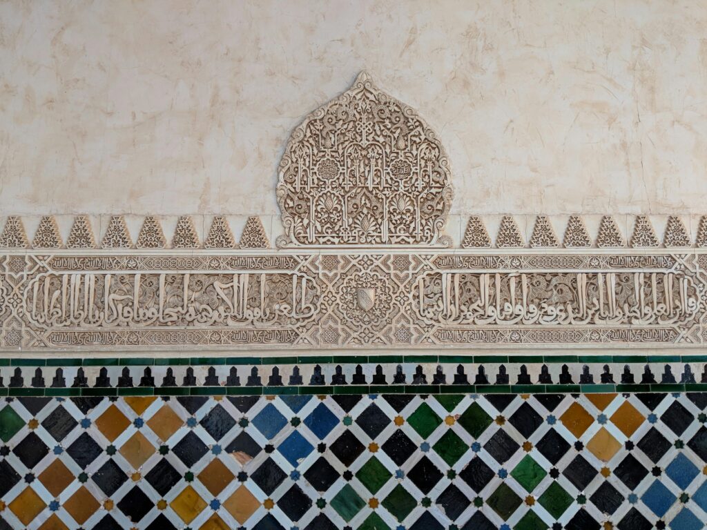 Detailed architectural wall design in Alhambra, Granada showcasing Islamic artistry.