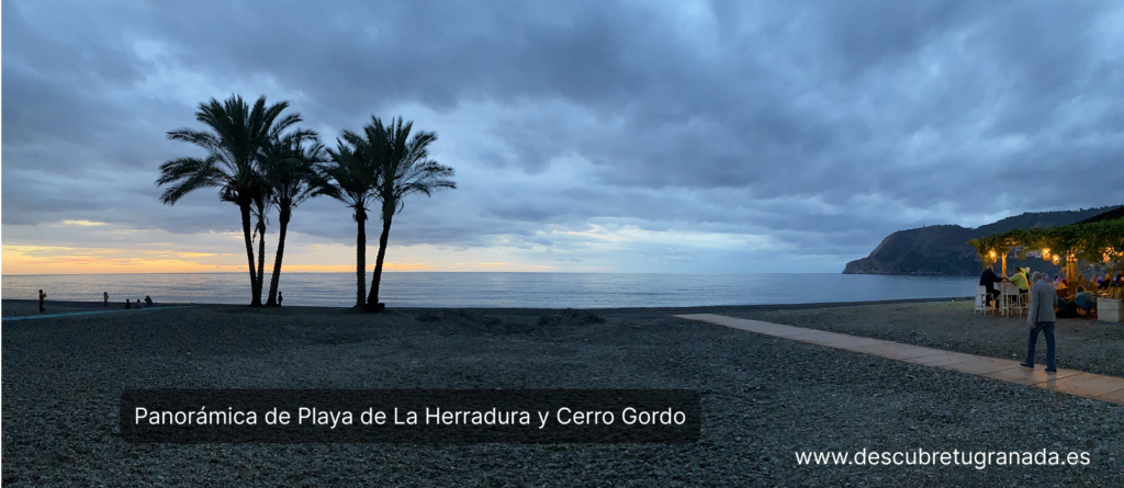 Playa de La Herradura y Cerro Gordo, vista por la tarde en un dia nublado con un chiringuito de la costa con música en directo